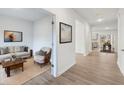 Hallway view with wood floors, neutral paint, and a glimpse into the living and dining spaces at 1462 Stephens View Dr, Loganville, GA 30052