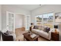 Bright living room featuring a comfortable beige couch, a view from the window, and a double door at 1462 Stephens View Dr, Loganville, GA 30052
