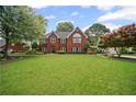 Classic brick home boasts a lush green lawn and inviting curb appeal at 6355 Stallion Dr, Cumming, GA 30040