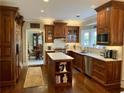 Gourmet kitchen featuring custom wood cabinetry, marble countertops, stainless steel appliances, and hardwood floors at 6355 Stallion Dr, Cumming, GA 30040