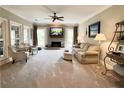 Spacious living room featuring a fireplace, plush carpeting, and abundant natural light from large windows at 6355 Stallion Dr, Cumming, GA 30040