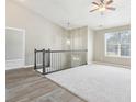 Bright and airy loft area with vaulted ceilings, a ceiling fan, carpet and new laminate floors, and a large window at 915 Terance Ave, Jonesboro, GA 30238