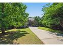 Inviting two-story home with a well-maintained lawn, a long driveway framed by mature trees at 3380 Canon Bay Dr, Cumming, GA 30041