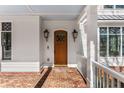 Charming entryway with a brick porch, beautiful wood door, and stylish lighting at 1271 Fenway Cir, Decatur, GA 30030