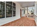 Classic front porch with brick flooring, white columns, and detailed window accents at 1271 Fenway Cir, Decatur, GA 30030