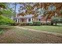 Charming one-story brick home with lush landscaping and a brick pathway leading to the front at 491 Hemlock Sw Dr, Marietta, GA 30064