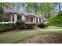 This one-story brick home is surrounded by mature trees and flowering bushes at 491 Hemlock Sw Dr, Marietta, GA 30064