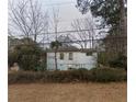 Quaint home with a visible foundation, set amidst lush trees and foliage in the backyard at 2010 Mcafee Pl, Decatur, GA 30032