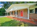 Close-up of a brick home with white trim, black shutters, and a striking red front door at 2683 Stardust Trl, Decatur, GA 30034