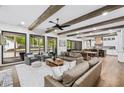 Open-concept living room with exposed beams, hardwood floors, and a view of the backyard pool at 604 Trinity Church Rd, Canton, GA 30115