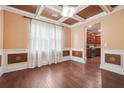 Elegant dining room with hardwood floors, coffered ceiling, and decorative wall paneling at 1340 Delo Ln, Cumming, GA 30041
