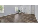 Bright living room featuring stylish wood floors, large windows, and access to the kitchen at 6597 Ivy Log Dr, Austell, GA 30168