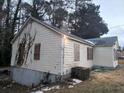 Rear exterior view of a one-story home with cream-colored siding and snow on the ground at 3238 Washington Rd, Atlanta, GA 30344
