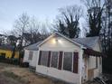 Exterior view of single-story home with cream siding, brown shutters, and mature trees at 3238 Washington Rd, Atlanta, GA 30344
