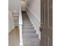 Entryway featuring a staircase with carpeted steps and a view into the living area with wood flooring at 3475 Ridge Hill Pkwy, Douglasville, GA 30135