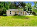 A well-kept single-story home with a green lawn, surrounded by mature trees creating a serene setting at 4002 Lindsey Dr, Decatur, GA 30035