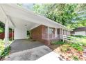 View of the house showing the covered carport and brick exterior, landscaped front yard with white picket fence at 844 Oak Nw St, Atlanta, GA 30318