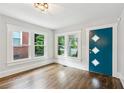 Bright entryway featuring hardwood floors, white trim, and a stylish teal door with geometric accents at 308 Mcpherson Se Pl, Atlanta, GA 30316