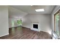 Bright living room featuring a fireplace, vaulted ceiling, skylight, and wood floors at 3445 Huntington Ct, Douglasville, GA 30134