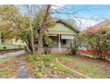 Curb view of charming home with covered front porch surrounded by foliage at 1388 Metropolitan Se Ave, Atlanta, GA 30316