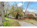 Quaint home with driveway, mature trees, and blossoming bushes in the yard at 1388 Metropolitan Se Ave, Atlanta, GA 30316
