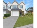 Attractive townhome featuring a one-car garage, driveway, and green lawn at 6918 Gallant Se Cir # 22, Mableton, GA 30126