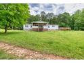 A single-story home features a front porch, wooden deck, green grass, and mature shade trees at 743 New Hope Rd, Lawrenceville, GA 30046