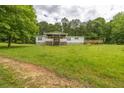 A single-story home features a front porch, wooden deck, green grass, and mature shade trees at 743 New Hope Rd, Lawrenceville, GA 30046