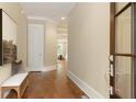 Elegant hallway featuring hardwood floors, neutral walls, crown molding, and a stylish bench near the front door at 385 Windy Pines Trl, Roswell, GA 30075