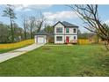 Inviting two-story home with a lush green lawn, white siding, and complementary black trim details at 1330 Adams Sw Dr, Atlanta, GA 30311