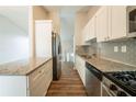 Modern kitchen featuring white cabinets, stainless steel appliances, and granite countertops at 6082 Raintree Bnd, Lithonia, GA 30058