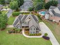 Aerial view of a stunning home with a pool, landscaping, and a long driveway at 6263 Fernstone Nw Trl, Acworth, GA 30101