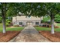 Back exterior of home featuring stone accents, manicured landscaping, and a private yard at 6263 Fernstone Nw Trl, Acworth, GA 30101