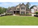 Charming stone and tan two-story home with manicured lawn and mature landscaping at 6263 Fernstone Nw Trl, Acworth, GA 30101