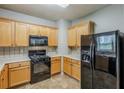 Practical kitchen with wooden cabinets, black appliances, and plenty of counter space for meal preparation at 8826 Lakecrest Way, Union City, GA 30291