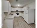 Bright kitchen featuring white cabinets, granite countertops, stainless appliances and new laminate flooring at 119 Michelle Dr, Mcdonough, GA 30252