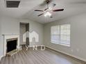 Cozy living room featuring a fireplace, ceiling fan and modern flooring and light-filled window at 119 Michelle Dr, Mcdonough, GA 30252