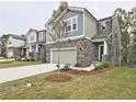 Attractive home showcasing a stone front, a two-car garage, and a manicured lawn in a lovely neighborhood at 3305 Morgan Rd, Buford, GA 30519