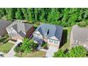 Aerial view showcases the home's roof, landscaped yard, and proximity to lush greenery and neighboring houses at 4610 Point Rock Dr, Buford, GA 30519