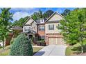 Charming home with mixed brick and siding, complemented by a well-maintained lawn and mature trees at 4610 Point Rock Dr, Buford, GA 30519
