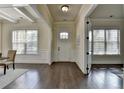 Elegant foyer with dark hardwood floors, white trim, paneled walls, and abundant natural light at 4610 Point Rock Dr, Buford, GA 30519