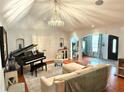 Elegant living room with a piano, vaulted ceilings, chandelier, and hardwood flooring at 3014 Echols Rd, Cumming, GA 30041