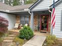 Charming front porch area with cozy seating, stone accents, and attractive landscaping at 5298 Autumn Run Dr, Powder Springs, GA 30127