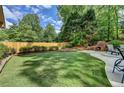 Expansive backyard featuring a well-maintained lawn, mature trees, and an outdoor fireplace at 5335 Bannergate Dr, Johns Creek, GA 30022