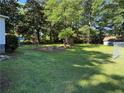 Large grassy backyard offering a serene outdoor space with shade trees and a storage shed at 1215 Sheppard Pl, Stone Mountain, GA 30083