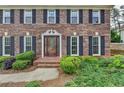 Up close view of the beautiful brick facade with black shutters and elegant front door entrance at 478 Guilford Cir, Marietta, GA 30068