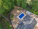 Aerial view of backyard featuring a private in-ground pool, outdoor seating, a fire pit, and tree coverage at 1125 Murray Sw Cir, Marietta, GA 30064