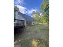Back exterior view of the home featuring a deck, covered patio, and fenced yard at 5028 Highway 81, Mcdonough, GA 30252