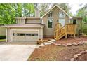 Two-story home boasts a well-manicured front yard and attached garage, offering both curb appeal and convenience at 2445 Deerfield Nw Dr, Kennesaw, GA 30144