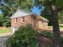 Rear exterior view of home, showing lush landscaping, brick and attached garage at 2059 Clearwater Se Dr, Marietta, GA 30067